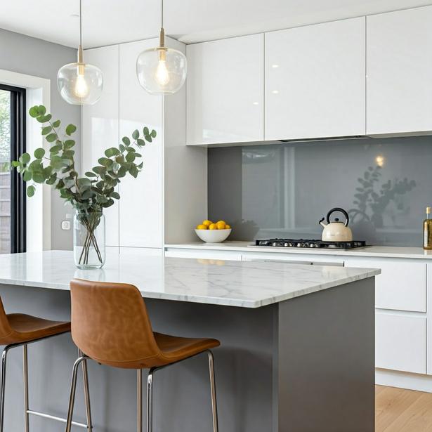 White kitchen with a marble island and glass pendant lights